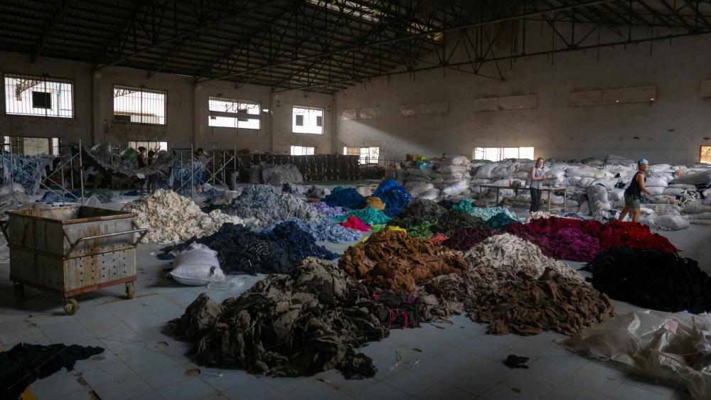 Sorting through hundreds of tons of clothing in an abandoned factory in Cambodia