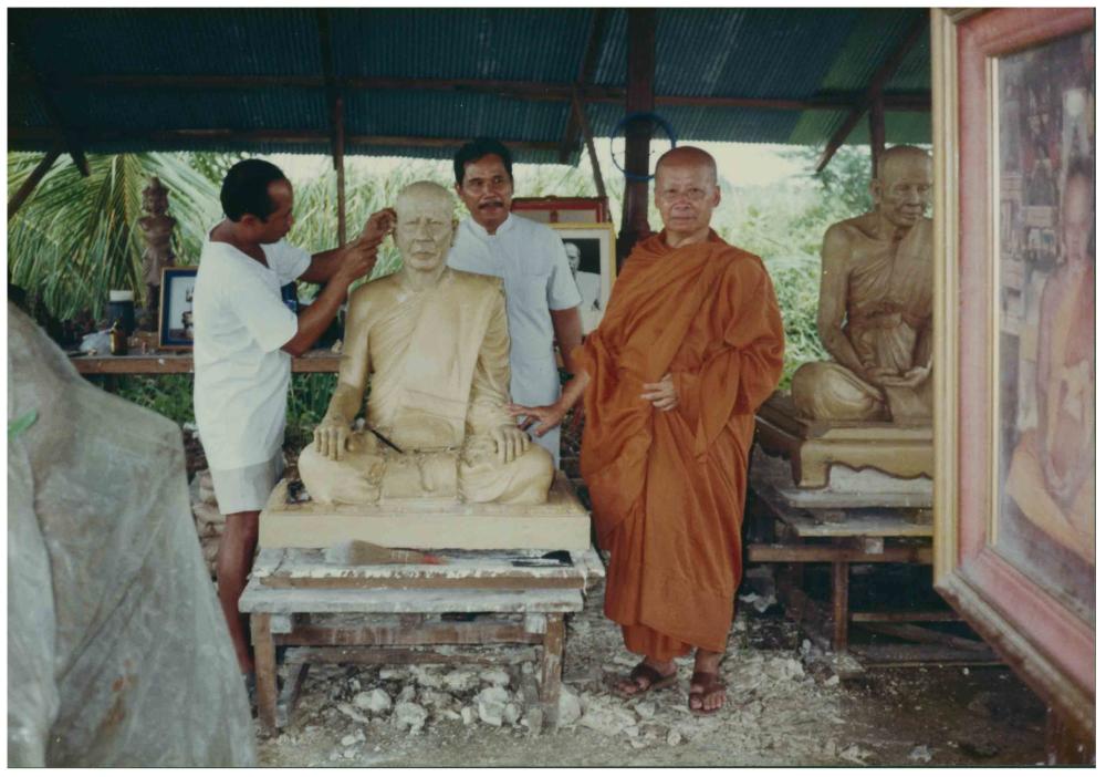 A Buddhist monk with the portrait sculpture of his preceptor in Laos