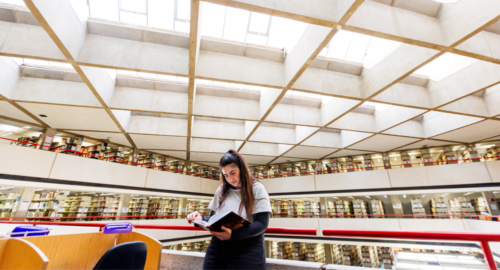 A student reading a book in the SOAS Library