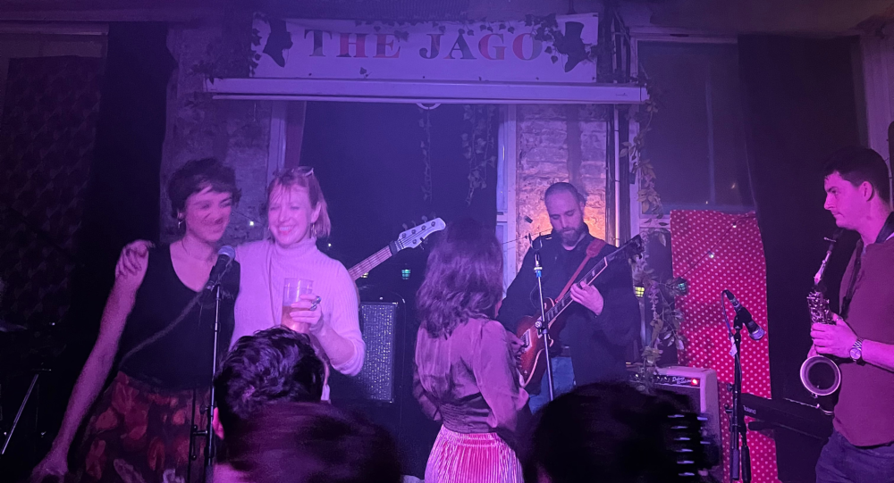 People smiling on stage at a music venue